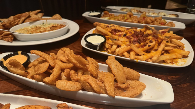 Variety of appetizers on brown, wooden table.