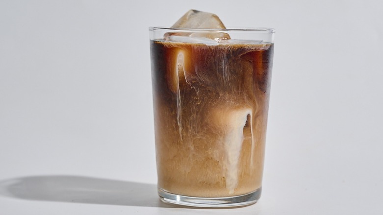 cup of iced coffee with creamer on a table