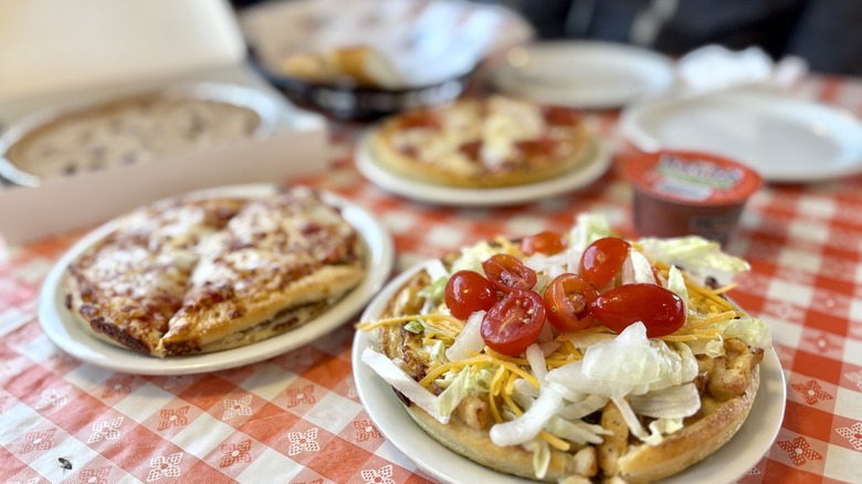 Pizza Hut pepperoni slices, cheese, and taco pizzas on a table at Pizza Hut Classic