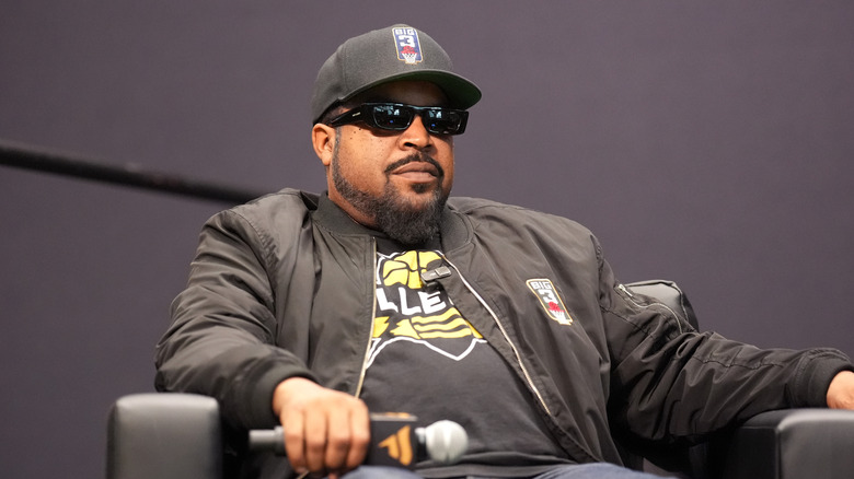 Rapper Ice Cube sitting in a chair on stage with a microphone