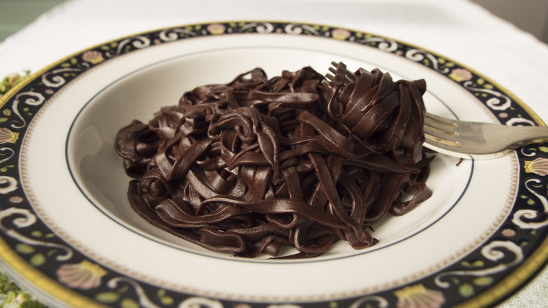 Plate of chocolate pasta with fork