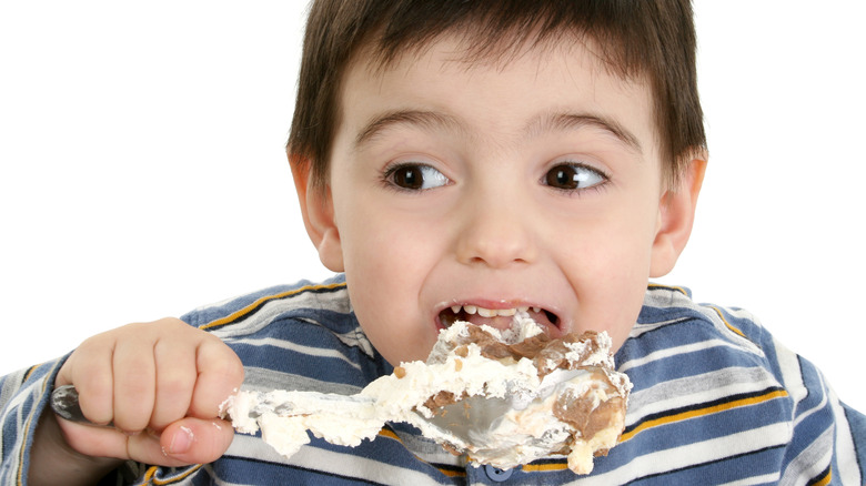 A boy eating a possum pie
