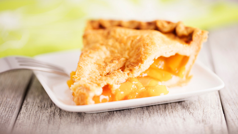 A slice of peach pie on a plate