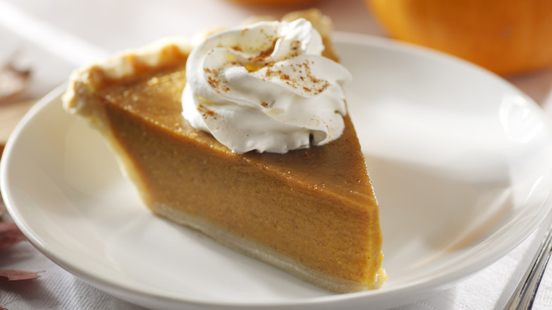 A slice of pumpkin pie on a plate