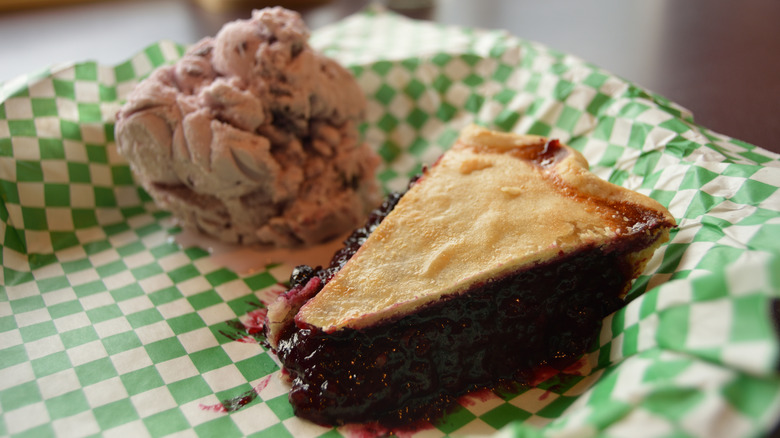 A slice of huckleberry pie with ice cream