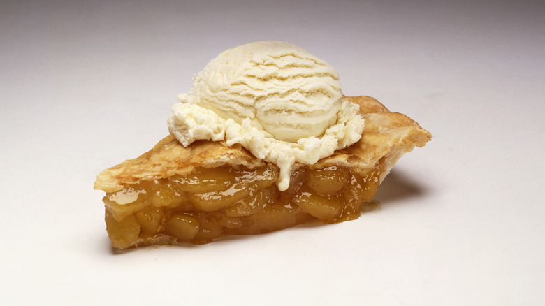 A slice of apple pie with ice cream on top