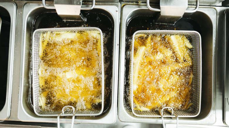 french fries cooking in tandem deep fryers