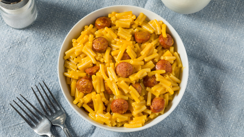 Bowl of mac and cheese with sliced hot dog pieces.