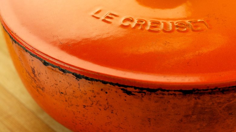 slightly stained orange le creuset dutch oven