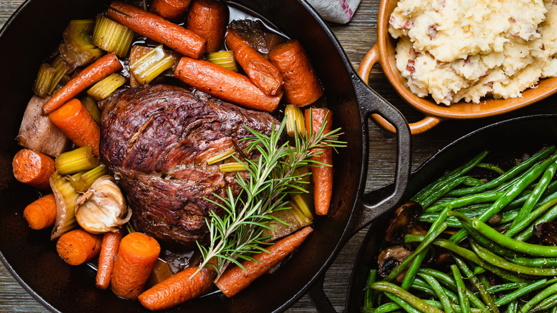 A pot roast surrounded by veggies if photographed from above.
