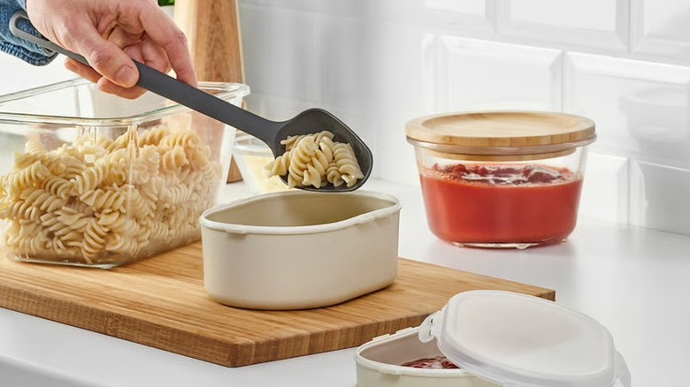 IKEA lunchbox set, person putting pasta inside the container