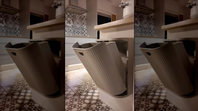 A Garsbutik trash can attached to a kitchen cabinet.