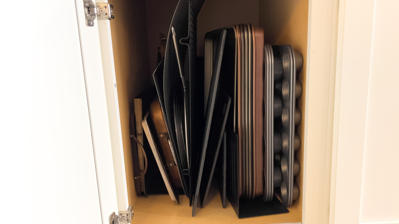 Internal kitchen cabinet storage of baking trays and cooling racks.