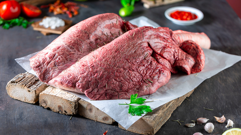 Two veal lungs on a wooden board.