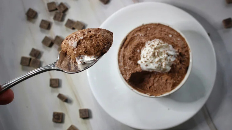 A spoon and ramekin of chocolate mousse