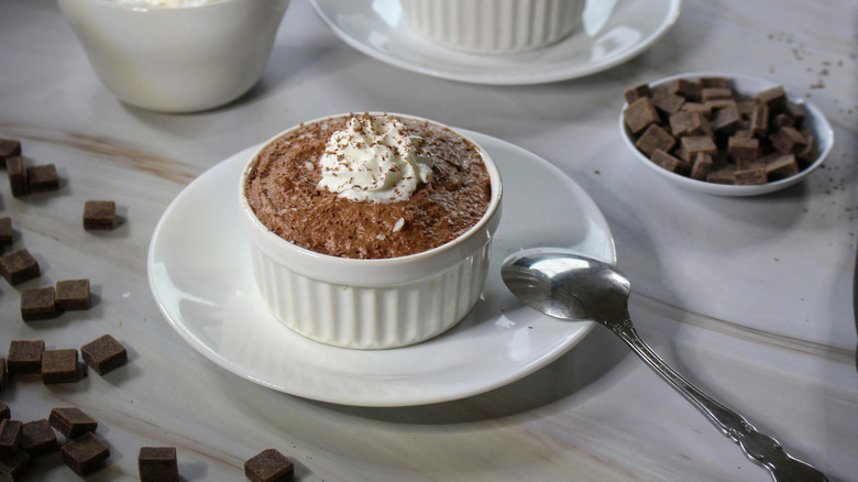A ramekin of chocolate mousse topped with whipped cream