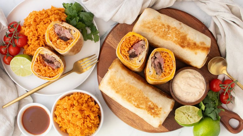 Overhead shot of Quesaritos, whole and halved, with seasoned rice on the side