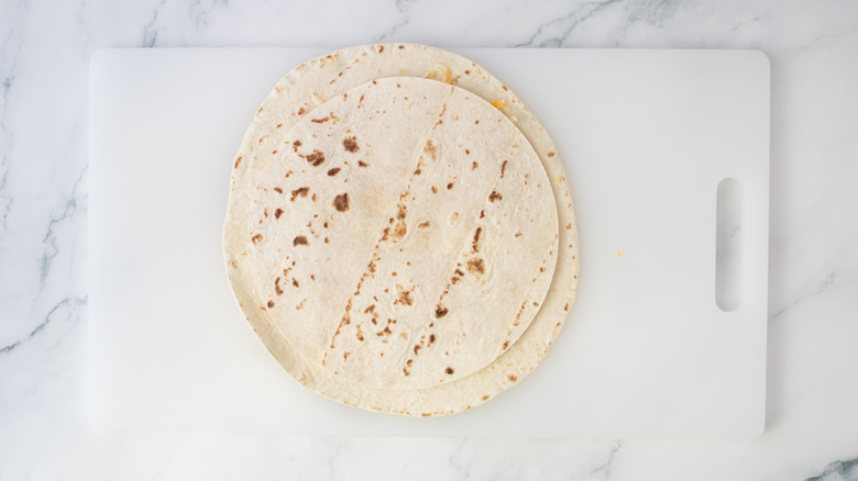 A smaller tortilla placed on top of a larger tortilla
