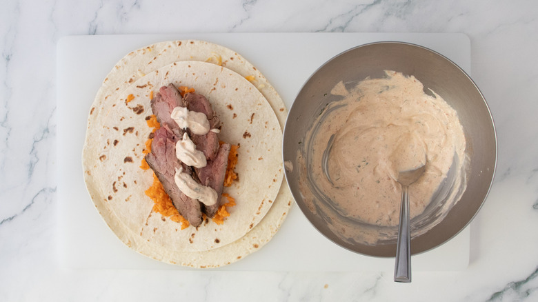 Steak and rice sauced in creamy chipotle sauce on top of tortillas