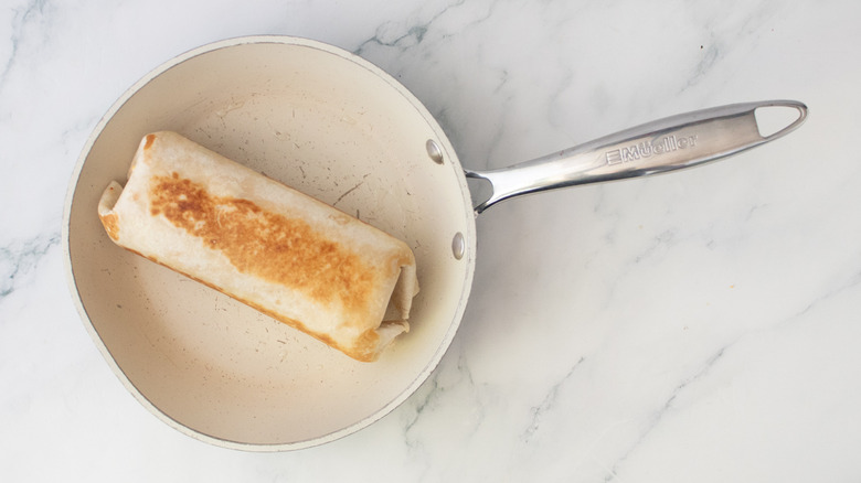A toasted burrito in a small nonstick skillet