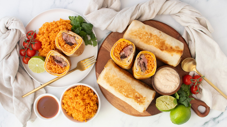 Overhead shot of Quesaritos, whole and halved, with seasoned rice on the side