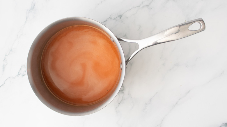 A medium saucepan filled with a red-tinted broth