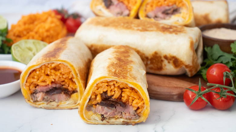 Side shot of a halved Quesaritos with seasoned rice on the side