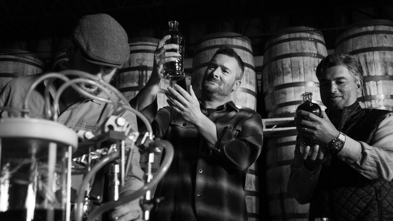 Ari Sussman, Eric Church, and Raj Alva looking at whiskey