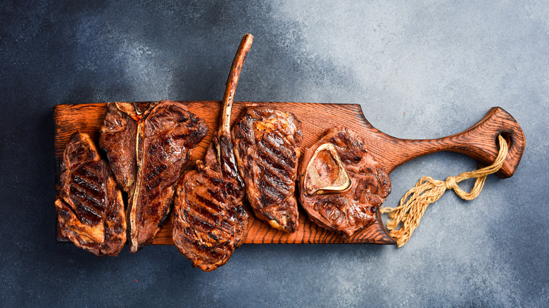 A variety of grilled steaks on a cutting board