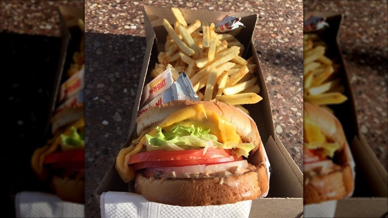 An In-N-Out grilled cheese with fries and ketchup packets in a cardboard takeout box