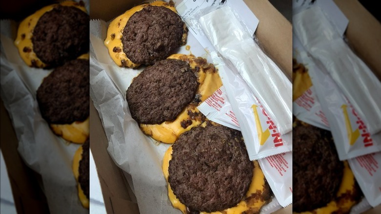 Three flying Dutchman burgers in a to-go box