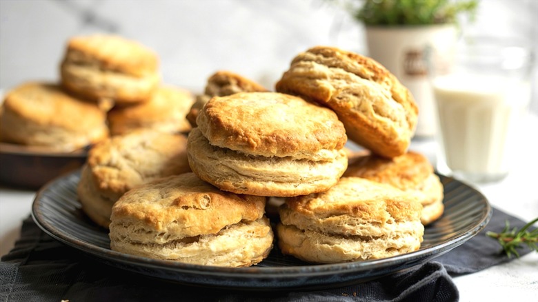 Buttermilk biscuits stacked on a dark gray plate over a gray cloth napkin