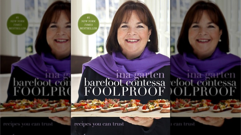 Book cover for Barefoot Contessa Foolproof, showing Ina Garten in a black shirt and purple scarf holding a tray of bruschetta-like canapes