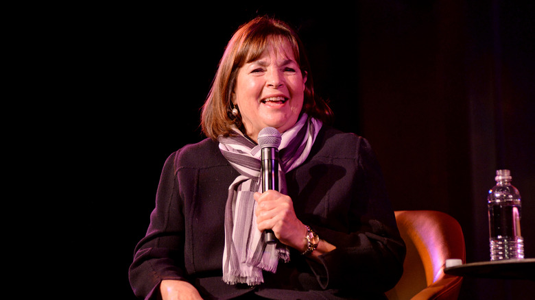 Ina Garten sitting in a brown leather chair speaking into a microphone