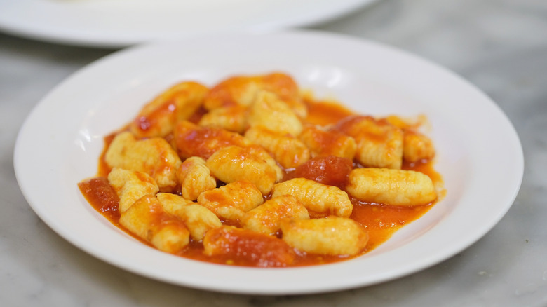 A white plate of chef Missy Robbins's gnocchi in red sauce.