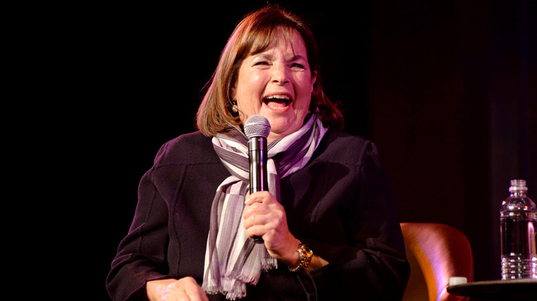 Ina Garten laughing while holding a microphone