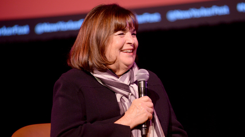 Ina Garten smiling while holding a microphone