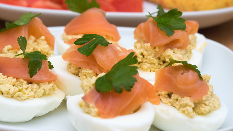 Deviled eggs with smoked salmon on top in close-up.