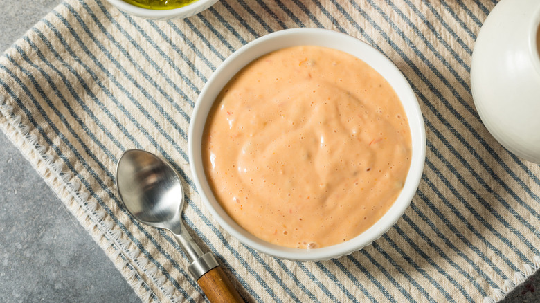 A ramekin of pale orange Thousand Island dressing.