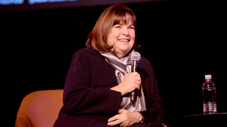 Celebrity chef Ina Garten smiles with a microphone on stage at an event.