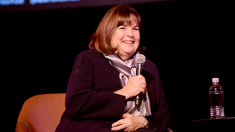 Ina Garten sitting in a chair and holding a microphone