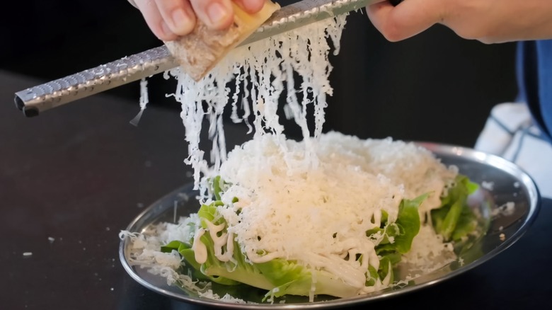A person grates cheese on a rasp