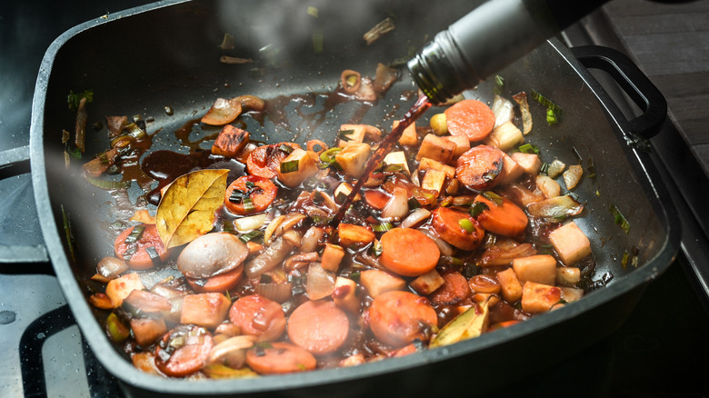 deglazing a pan of roasted vegetables with red wine