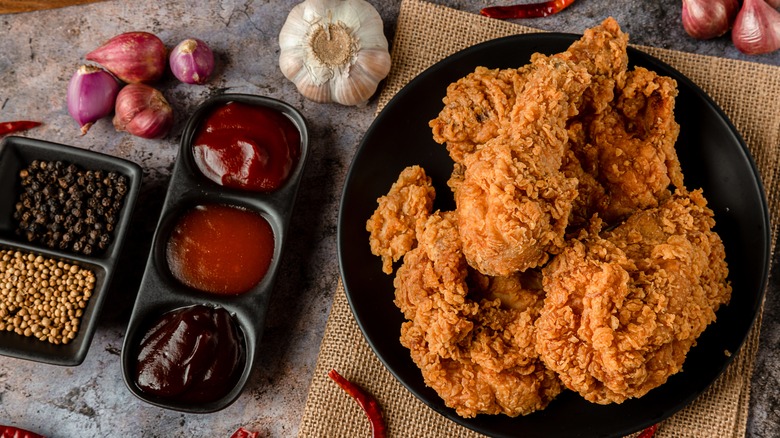 Fried chicken next to sauces and spices