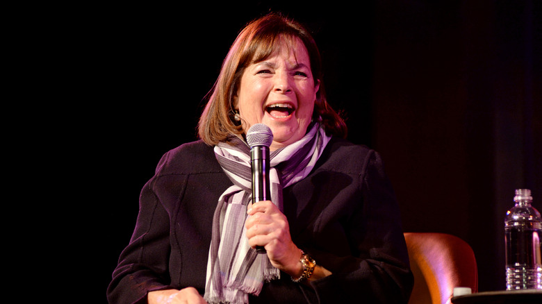 Ina Garten laughing while holding a microphone