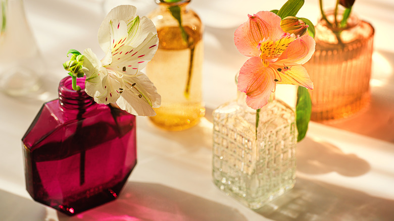 Individual lilies in small colorful vases