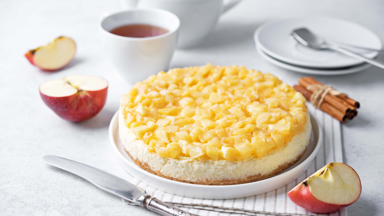 A cheesecake topped with pieces of apple