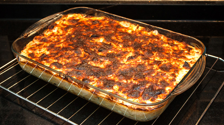 A casserole in a glass pan resting on a wire rack