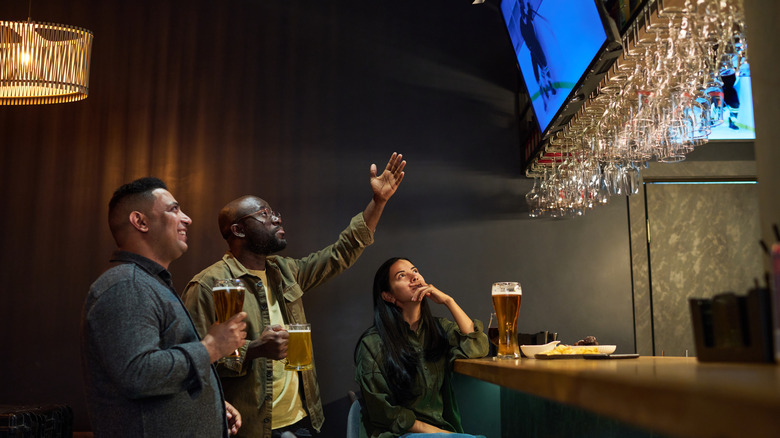 People watching hockey and drinking beer in a sports bar