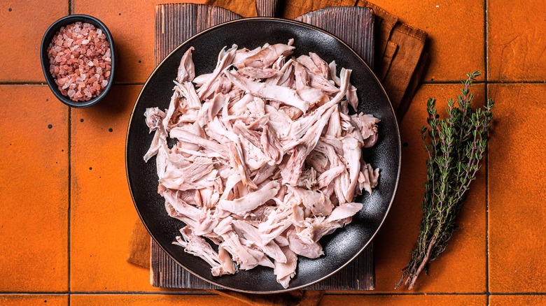 Cooked pink shredded chicken in bowl